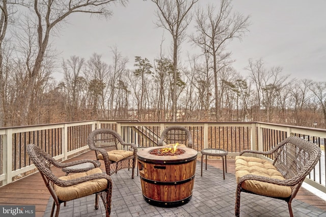 wooden terrace featuring a fire pit and a patio