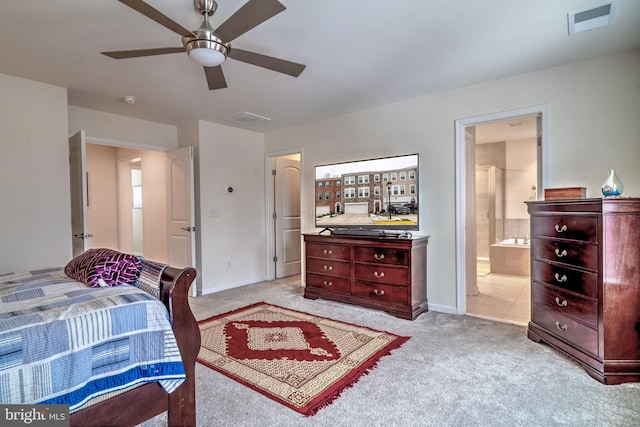 bedroom with ceiling fan, light carpet, and ensuite bath