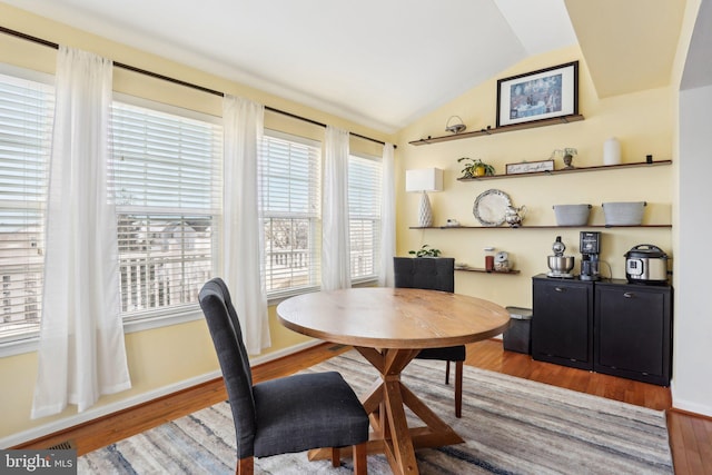 dining area with lofted ceiling and wood-type flooring