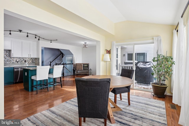 dining room with lofted ceiling and dark hardwood / wood-style flooring