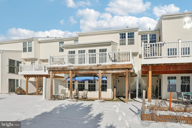 snow covered rear of property featuring a deck