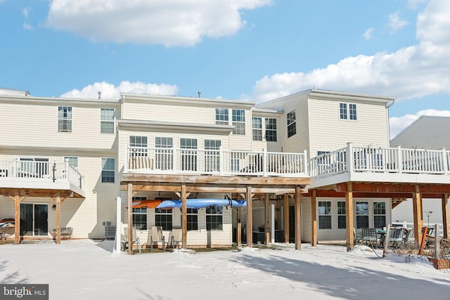 snow covered rear of property with a deck