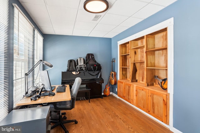 home office featuring a drop ceiling and hardwood / wood-style flooring