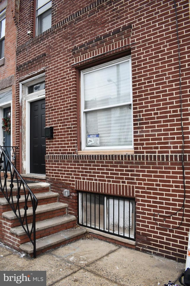 entrance to property featuring brick siding