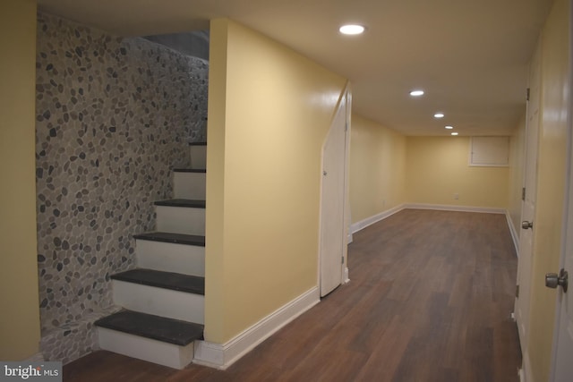 finished below grade area featuring baseboards, stairway, dark wood finished floors, and recessed lighting