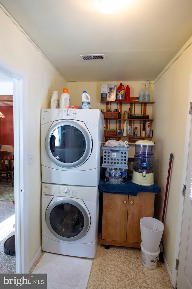 clothes washing area with stacked washer and dryer