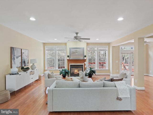 living room featuring light hardwood / wood-style floors and ceiling fan