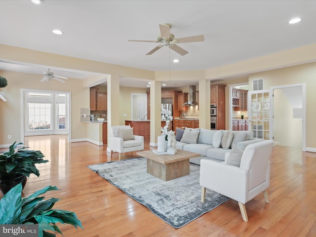 living room with ceiling fan and light wood-type flooring