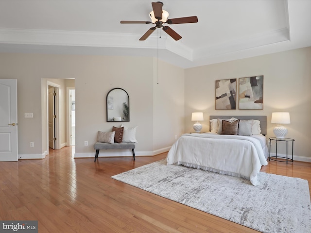 bedroom featuring ornamental molding, a tray ceiling, and hardwood / wood-style floors