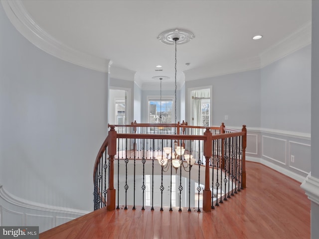 hall with crown molding, a chandelier, and light wood-type flooring