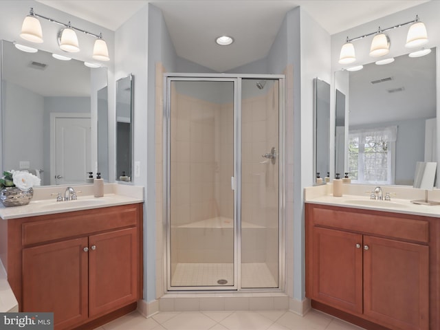 bathroom featuring vanity, a shower with shower door, and tile patterned flooring