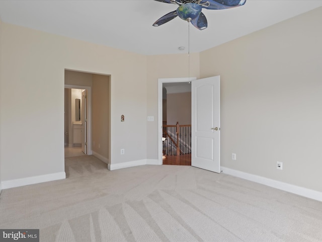 unfurnished bedroom featuring ceiling fan, ensuite bathroom, and light carpet