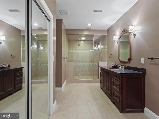 bathroom with tile patterned floors, vanity, and an enclosed shower