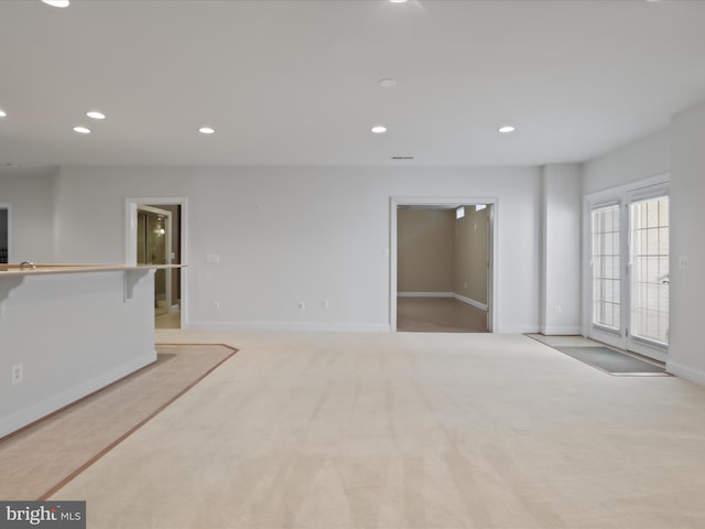 unfurnished living room with light colored carpet