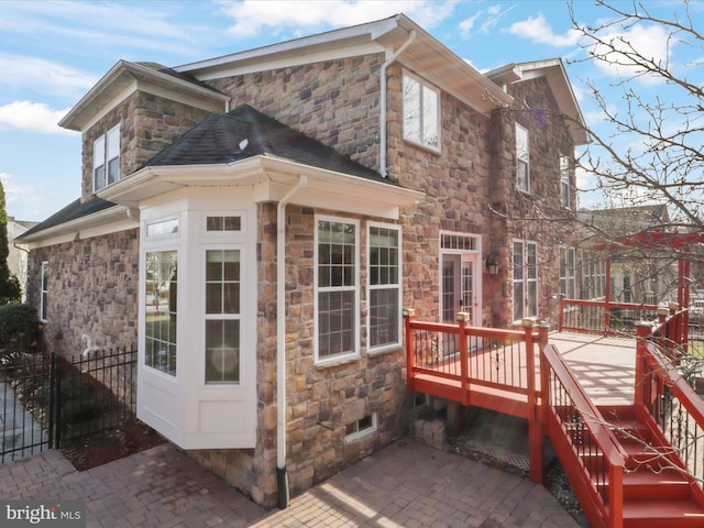 view of side of property featuring a deck and a patio area