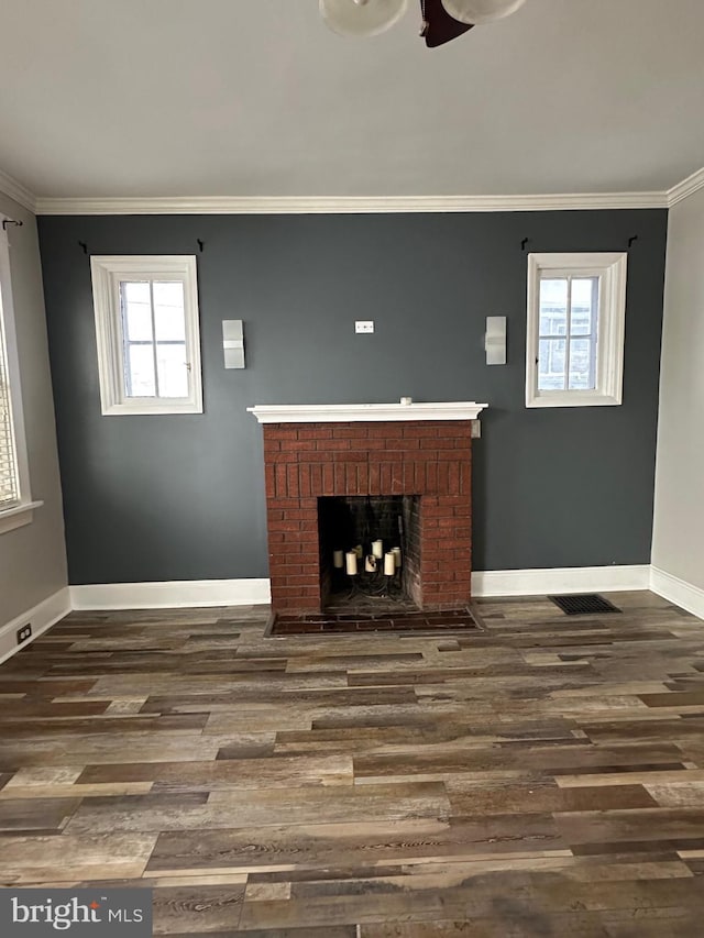 unfurnished living room with ornamental molding, a brick fireplace, and a wealth of natural light