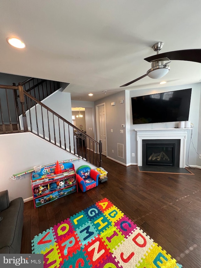 rec room with dark hardwood / wood-style floors and a chandelier