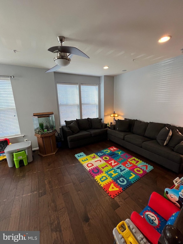 living room featuring dark wood-type flooring and ceiling fan