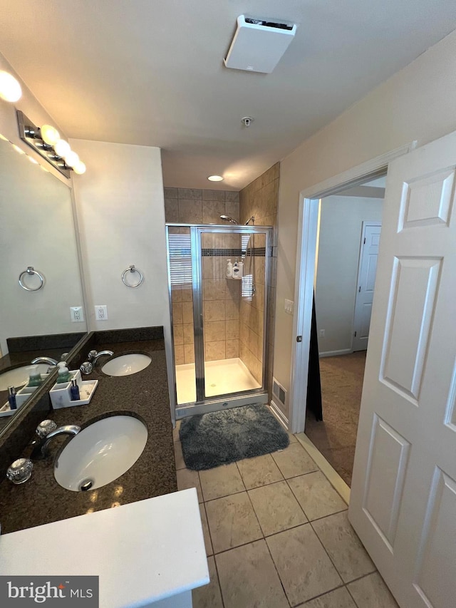 bathroom featuring tile patterned floors, a shower with shower door, and vanity