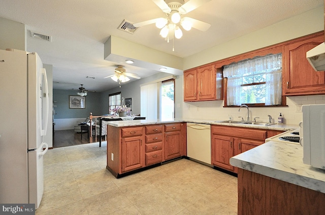 kitchen featuring tasteful backsplash, sink, ceiling fan, kitchen peninsula, and white appliances