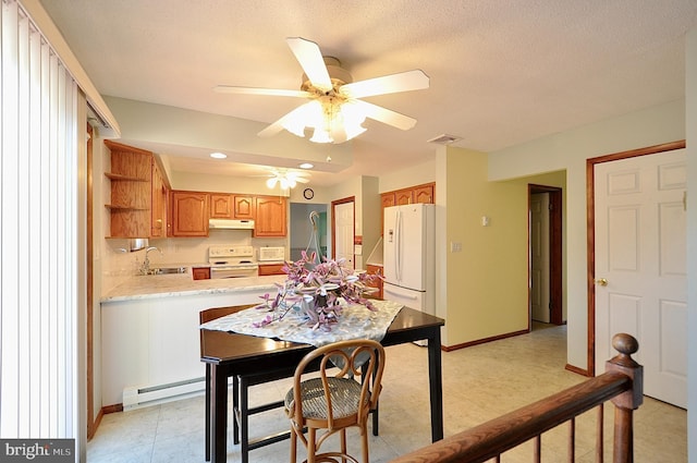 dining room featuring baseboard heating, ceiling fan, and sink