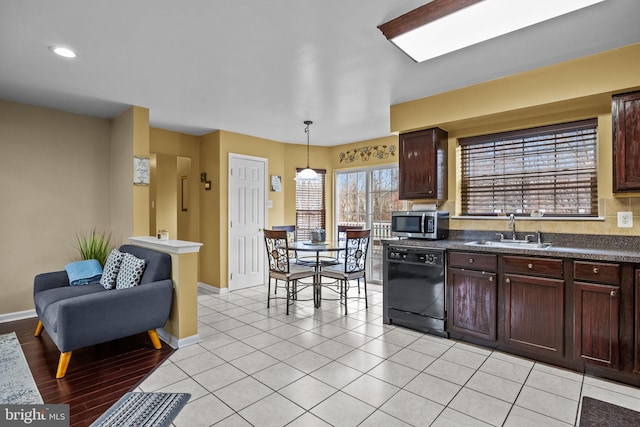 kitchen featuring dishwasher, sink, dark brown cabinetry, hanging light fixtures, and light tile patterned floors