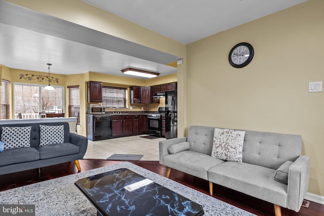 living room featuring sink and light hardwood / wood-style floors