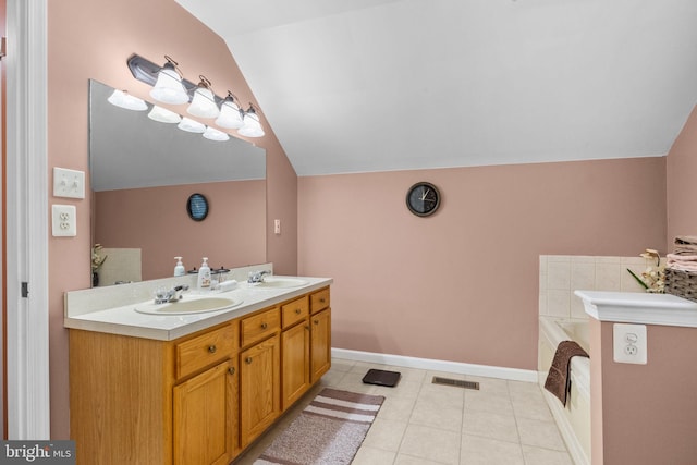 bathroom with a tub to relax in, lofted ceiling, tile patterned floors, and vanity