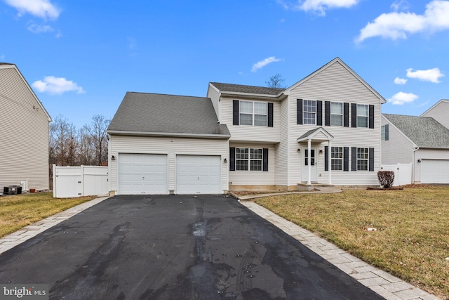 view of front of home with a front lawn, a garage, and cooling unit