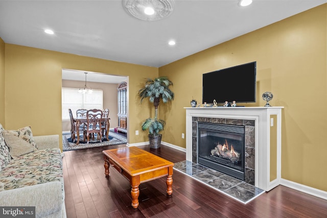 living room featuring a high end fireplace and dark hardwood / wood-style flooring