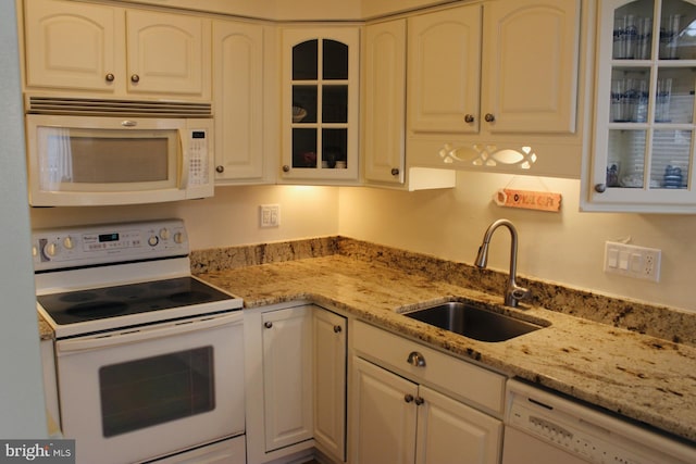 kitchen featuring white cabinetry, white appliances, sink, and light stone counters