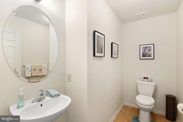 bathroom with sink, wood-type flooring, and toilet