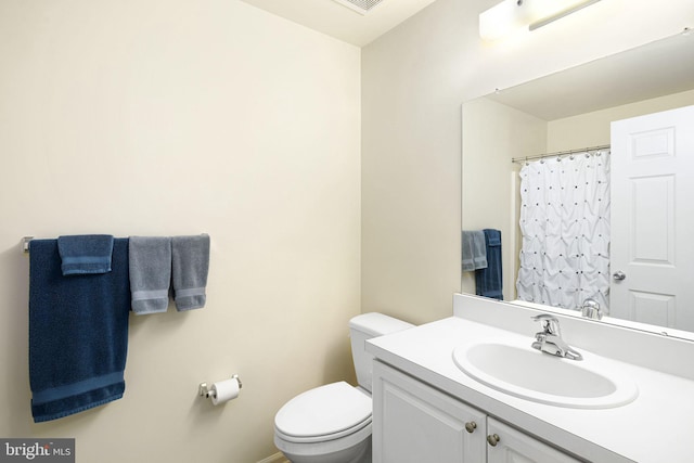 bathroom featuring vanity, toilet, and curtained shower