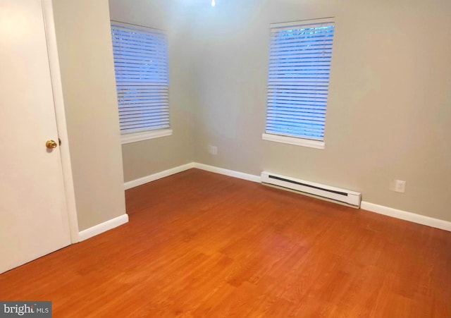 spare room featuring a baseboard radiator and hardwood / wood-style floors