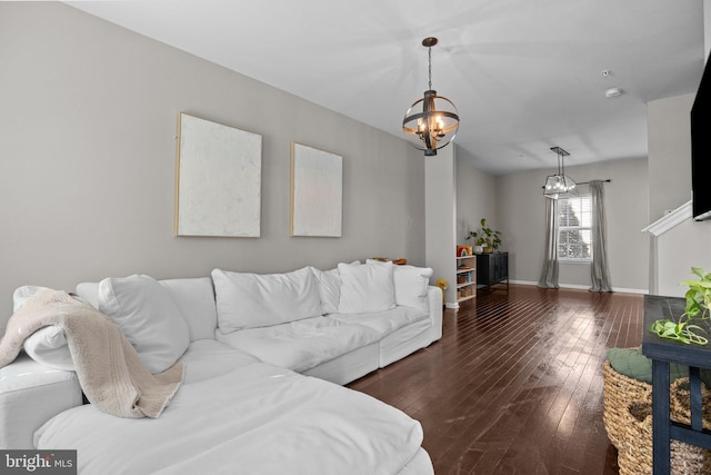 living room featuring dark wood-type flooring and a notable chandelier