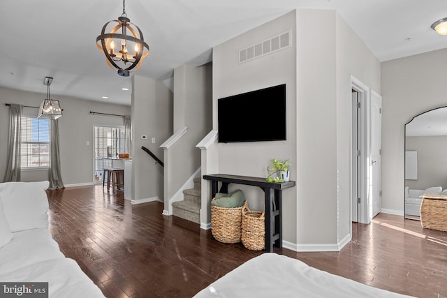 living room with dark wood-type flooring and a chandelier