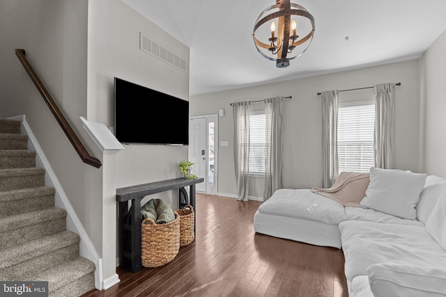 living room with dark wood-type flooring and a notable chandelier