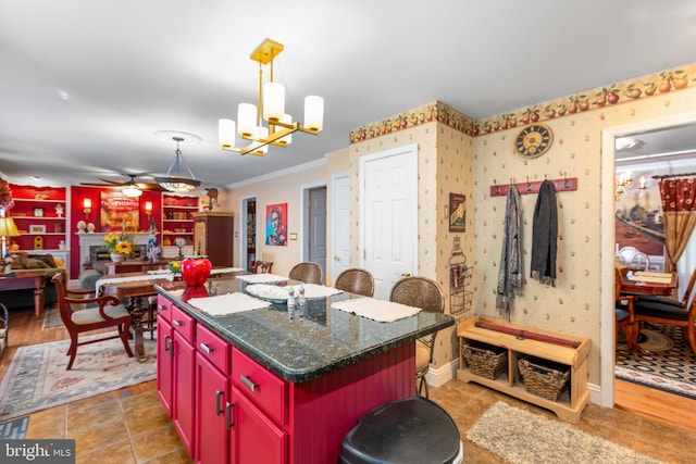 kitchen featuring hanging light fixtures, a kitchen bar, ornamental molding, and a kitchen island