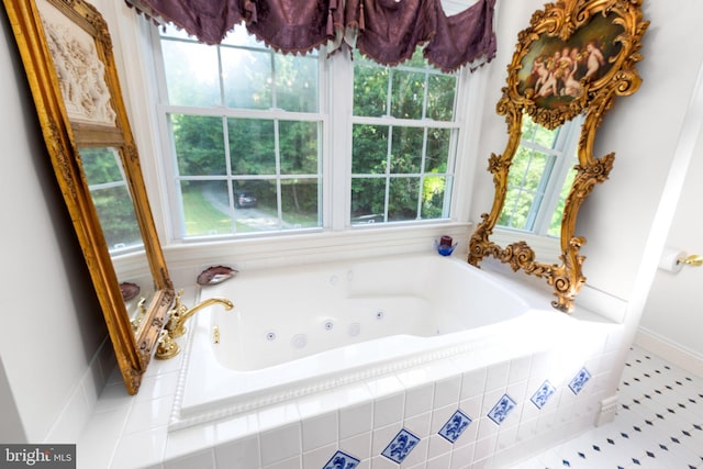 bathroom with tiled bath, a healthy amount of sunlight, and tile patterned floors