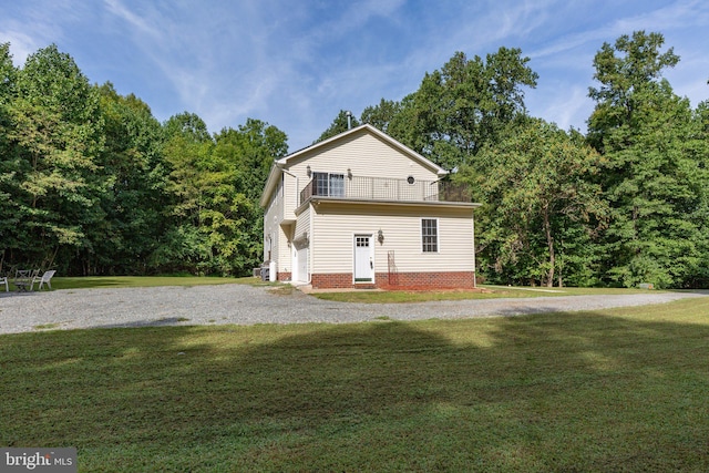 view of front of house with a balcony and a front yard