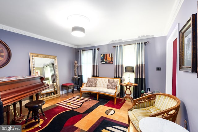 sitting room with ornamental molding and wood-type flooring