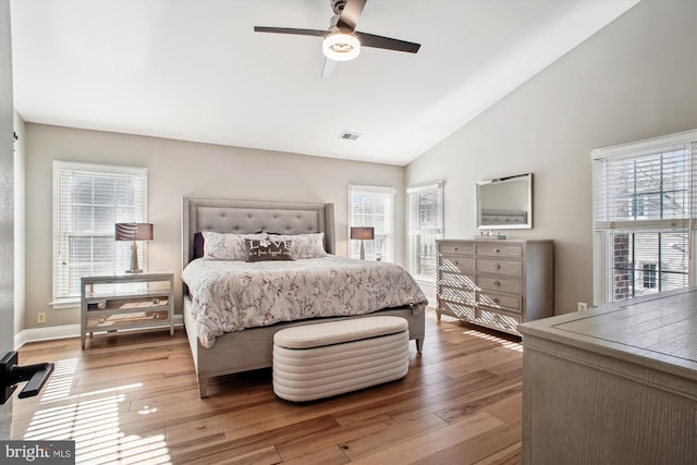 bedroom with multiple windows, high vaulted ceiling, ceiling fan, and light hardwood / wood-style flooring