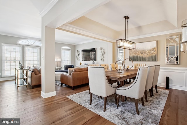 dining area with hardwood / wood-style flooring, ornamental molding, and a wealth of natural light