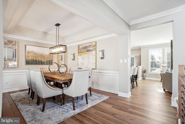 dining area with ornamental molding, hardwood / wood-style floors, and a notable chandelier