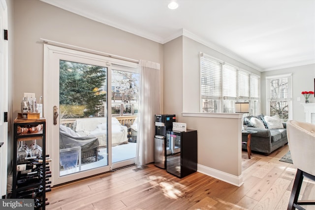 doorway to outside featuring crown molding and light hardwood / wood-style flooring