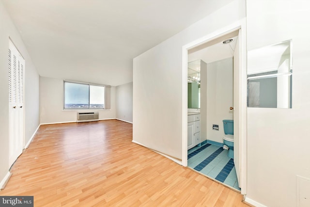 corridor with hardwood / wood-style floors and a wall mounted air conditioner