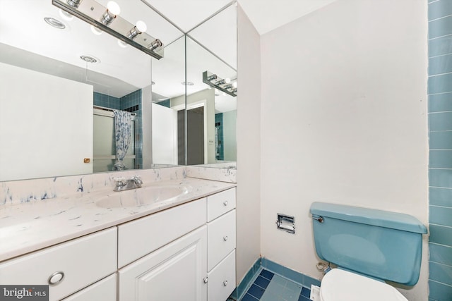 bathroom featuring toilet, vanity, tile patterned floors, and walk in shower