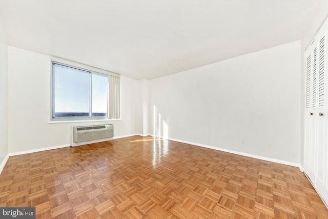 unfurnished room featuring a wall unit AC and light parquet floors