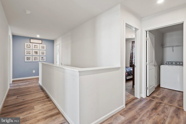 corridor with dark wood-type flooring and washer / clothes dryer