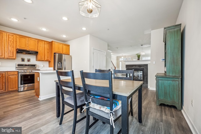 kitchen featuring hardwood / wood-style floors, a center island, stainless steel appliances, and hanging light fixtures